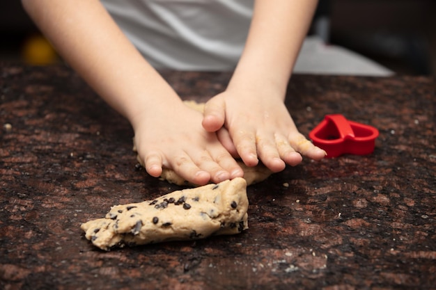 Kinderhände hautnah, die Kekse in der Küche zubereiten