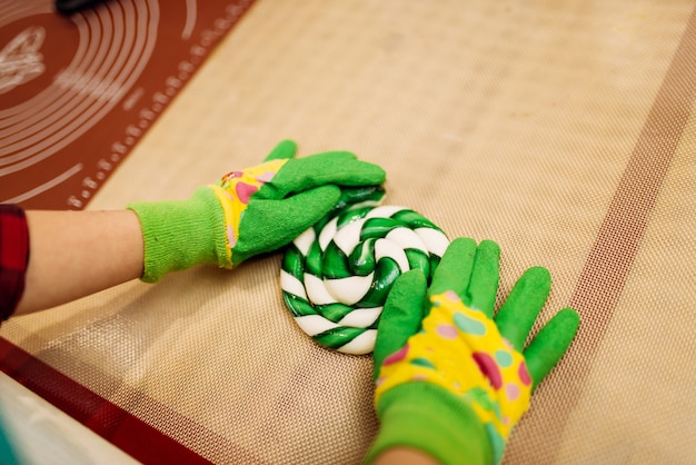 Kinderhände in Handschuhen, die Karamellbonbons machen