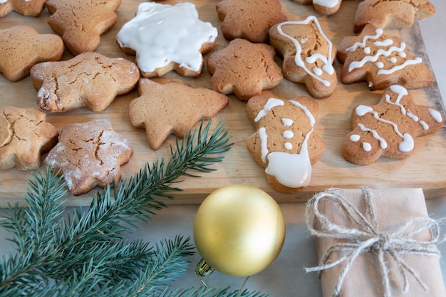 Kinderhände machen Neujahrs-Lebkuchen auf einem Holztisch. Kekse mit einem Ausstecher backen. Neujahrs- und Weihnachtskonzept.