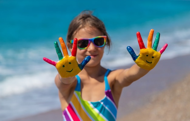 Kinderhände mit Farben auf dem Meer bemalt. Selektiver Fokus. Kind.