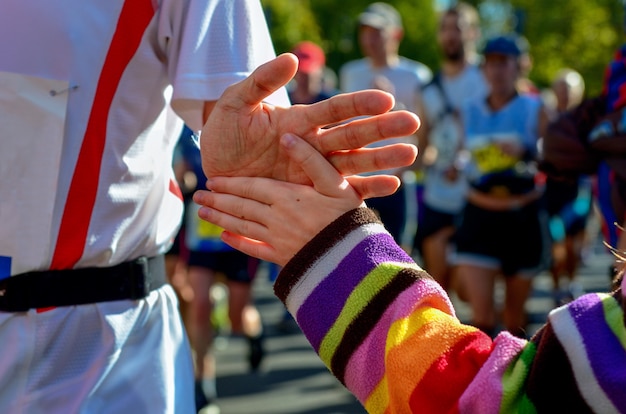 Kinderhand geben High Five in einem Marathonlauf