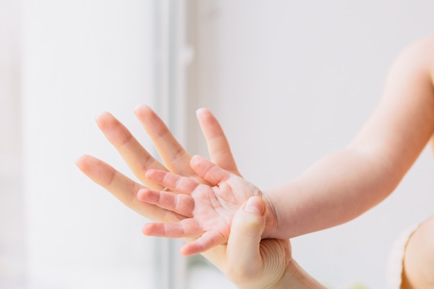 Kinderhand in Mutterhand. Mutter hält Tochterhand. Familie