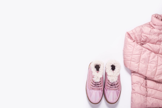 Foto kinderjacke und stiefel für ein mädchen auf weißem hintergrund. ansicht von oben, flach. banner.