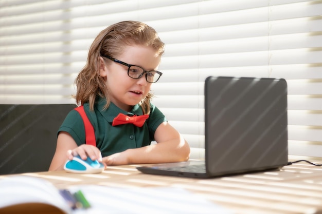 Kinderjunge, der einen Laptop benutzt und Online-Unterrichtsschüler in der Schule studiert süßes Kind mit Laptop-Computer st ...