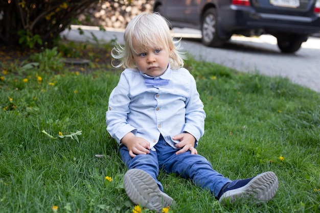 Kinderjunge, der im blühenden Garten der Kirschblüte spielt