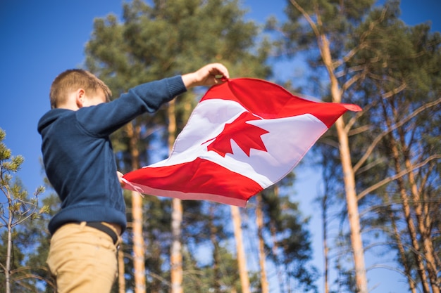 Kinderjunge, der Kanada-Flagge hält. Kanadischer Nationalfeiertag. 1. Juli.