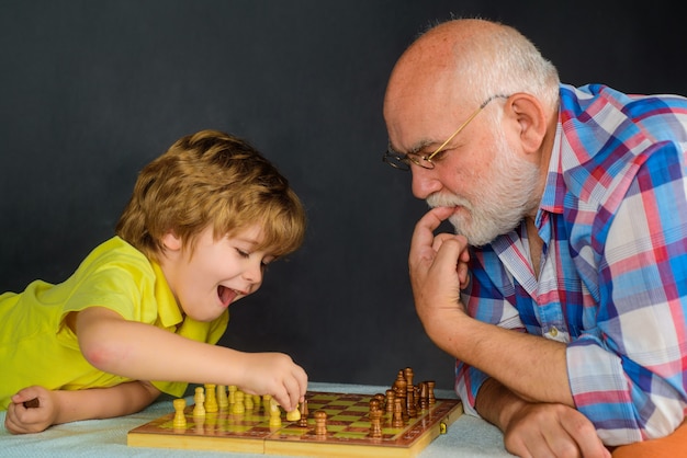 Kinderjunge, der Schach mit Großvater-Gehirnentwicklung und Logikkonzept-Schachwettbewerb spielt