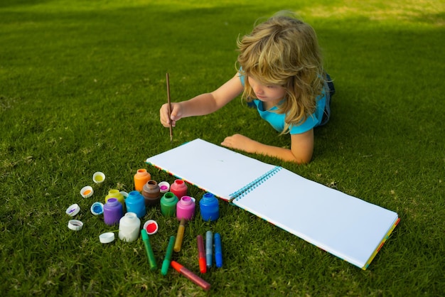 Kinderjunge genießen Kunst- und Handwerkszeichnungen im Hinterhof oder im Frühlingspark Kinderzeichnung zeichnen mit Bleistift ...