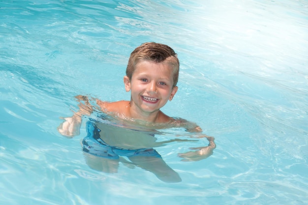 Foto kinderjunge im swimmingpool lächelnd