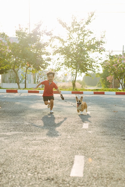 Kinderjunge läuft mit seinem Hund auf der Straße