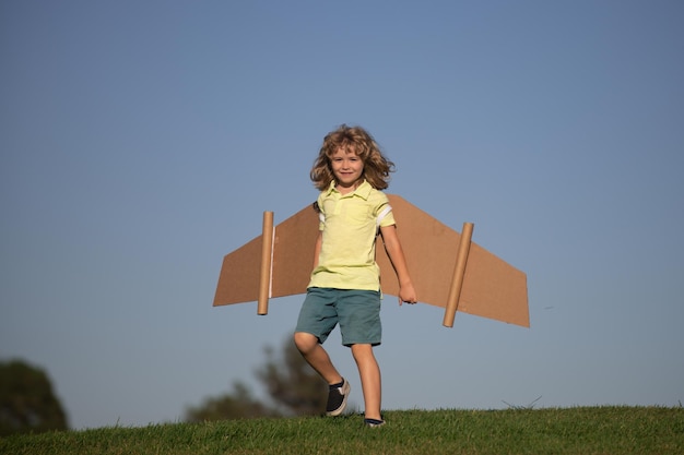 Kinderjunge spielt Pilotastronautenkind, das davon träumt, ein Flieger-Raumfahrerkind zu werden, das mit einem Auto spielt