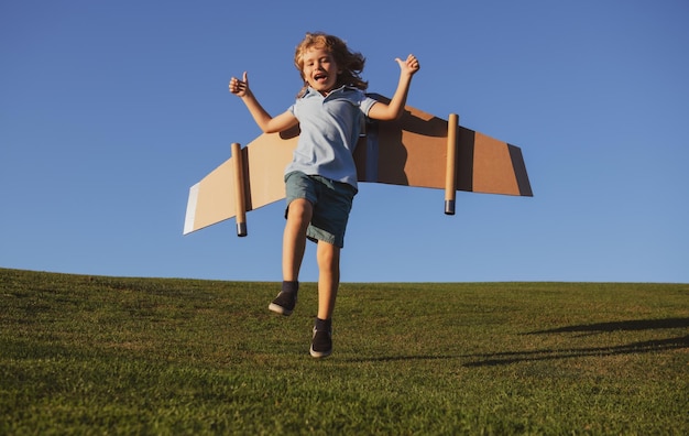 Kinderjunge träumt und reist Junge springt und läuft mit Flugzeugspielzeug im Freien Glückliches spielendes Kind