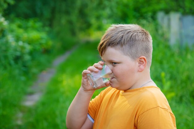 Kinderjunge trinkt Wasser aus einem Glas.