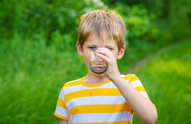 Kinderjunge trinkt Wasser aus einem Glas.