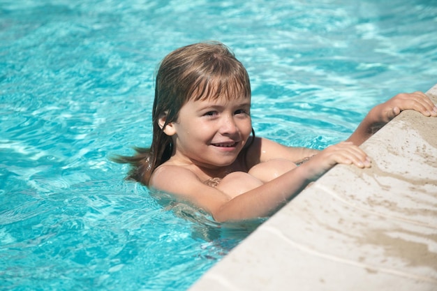 Kinderjungenschwimmen im Swimmingpool scherzt Sommerferienkonzept