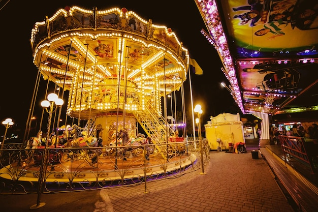 Kinderkarussell in einem Vergnügungspark im Vergnügungspark mit Nachtbeleuchtung bei Nacht