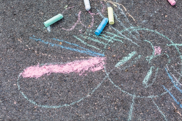 Foto kinderkreidekunst auf schwarzem bürgersteig.