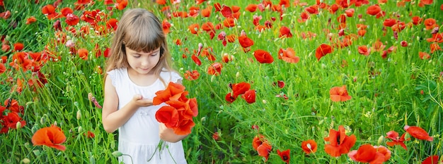 Kindermädchen auf einem Feld mit Mohnblumen.