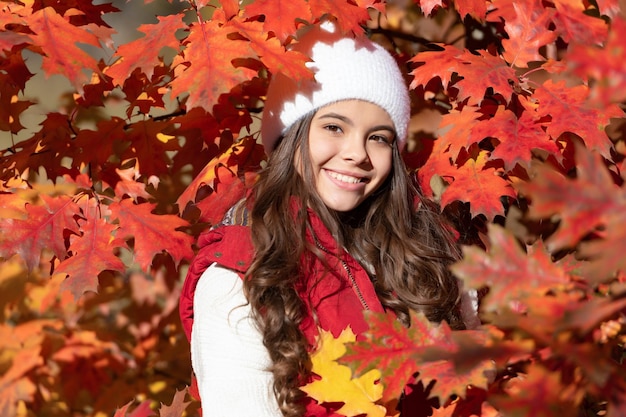 Kindermädchen auf Herbsthintergrund Herbstkinder stehen fröhlichem Kind mit Hut im Herbstlaub auf natürlichem Hintergrund gegenüber