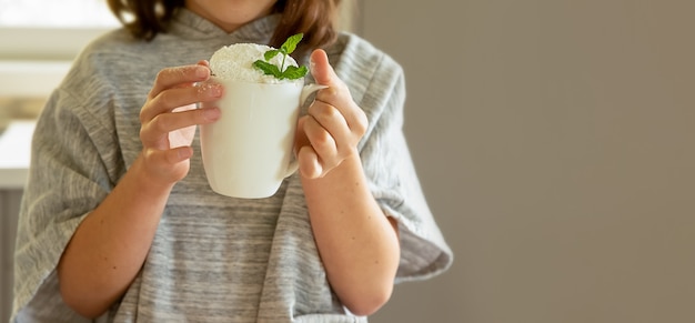 Kindermädchen, das eine Tasse mit süßem Dessert hält