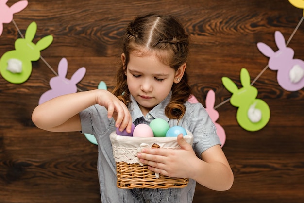 Kindermädchen, das Korb mit Ostern hält