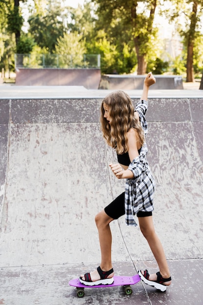 Kindermädchen fahren auf Penny Board oder Skateboard Sportgeräte für Kinder Teenager mit Penny Board auf dem Spielplatz im Skatepark