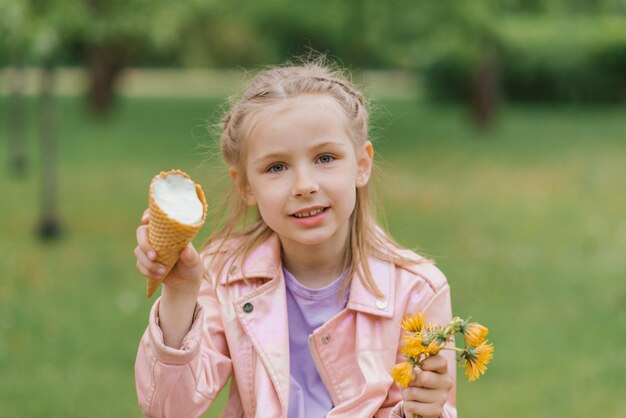 Kindermädchen hält im Frühling im Park eine Eistüte in ihren Händen