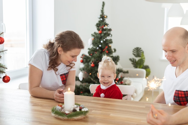 Kindermädchen im Weihnachtskleid mit Cochlea-Implantaten, die sich zu Hause amüsieren, Vielfalt und Hören