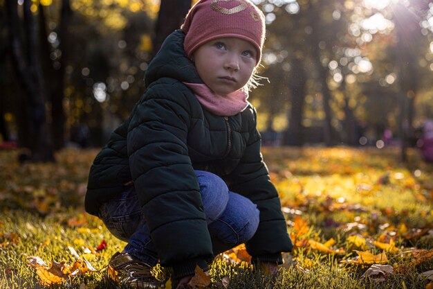 Kindermädchen mit Hut in einem Herbstpark an einem sonnigen Tag.