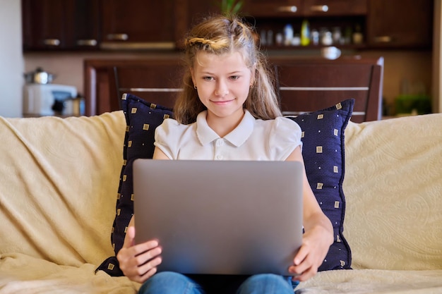 Kindermädchen mit Laptop zu Hause auf der Couch