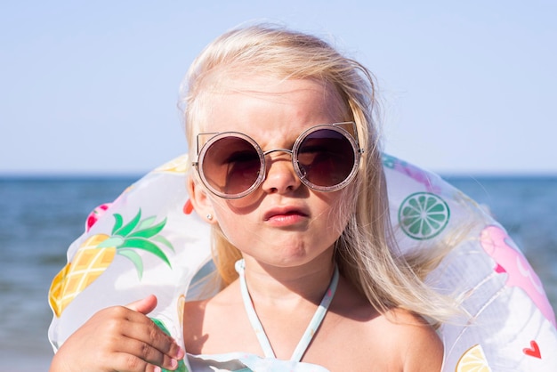 Kindermädchen mit Sonnenbrille mit Gummiring am Strand