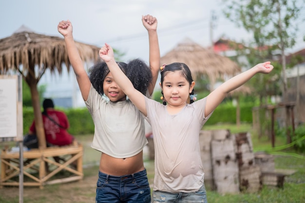 Kindermädchen nass im Regen Afroamerikanisches Mädchen und asiatische Freundin