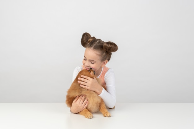 Kindermädchen playig mit Spitzhund