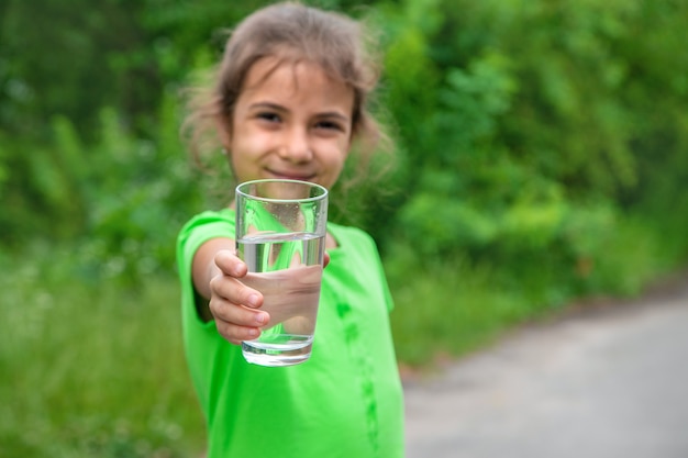 Kindermädchen trinkt Wasser aus einem Glas. Selektiver Fokus. Kind.