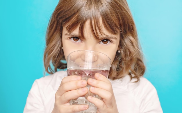 Kindermädchen trinkt Wasser aus einem Glas Selektiver Fokus