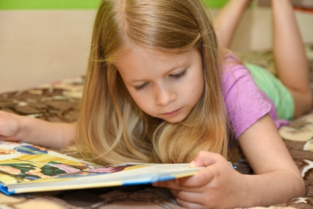 Kindermädchenlesebuch im Bett zu Hause.