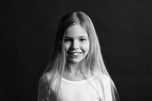 Kindermodell, das mit dem langen gesunden Haar lächelt