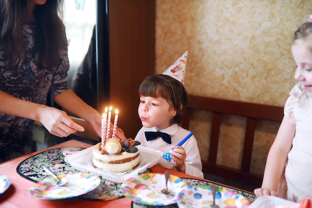 Kinderparty in Mützen feiert Geburtstag mit Kuchen und Luftballons bei homexA