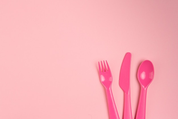 Foto kinderplastikgeschirr auf einem rosa hintergrund