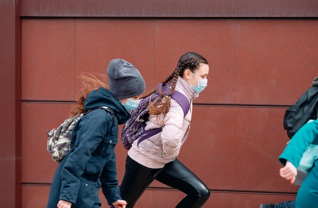 Kinderschüler in medizinischen Masken verlassen die Schule.