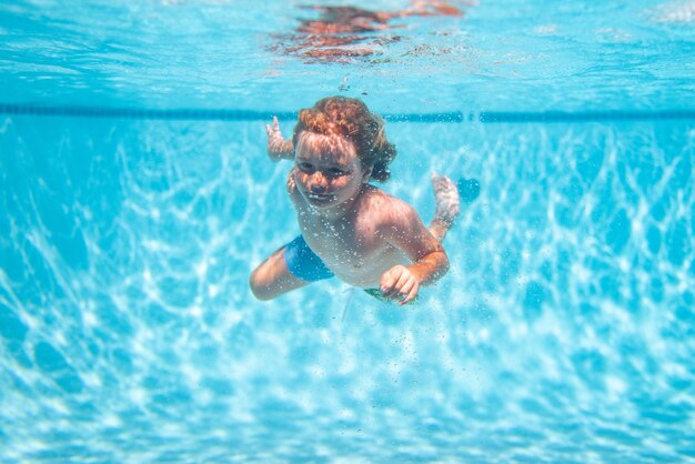 Kinderschwimmen im Pool unter Wasser Kinderjunge schwimmt unter Wasser im Pool