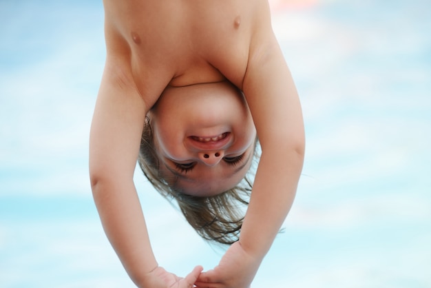 Kinderspaß, der mit Wasser auf Sommerpool spielt