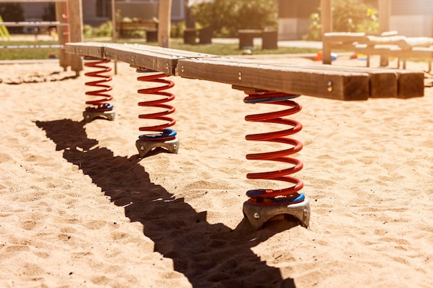 Kinderspielplatz mit moderner SwingSpring-Spiralbank im Garten. Moderner Spielplatz-Hintergrund.