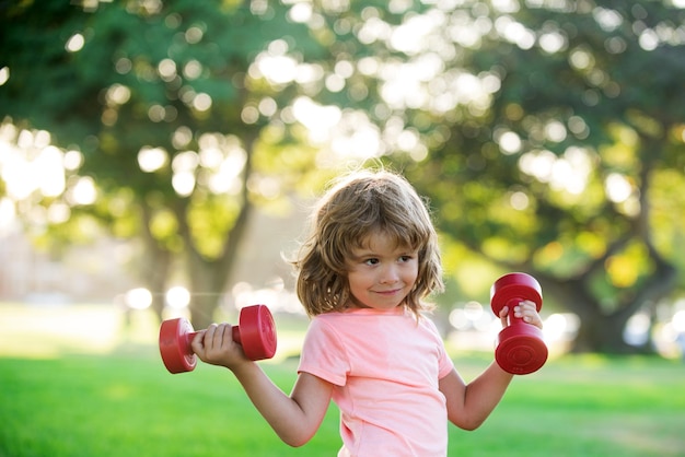 Kindersport Junge trainiert im Park Aktiver gesunder Lebensstil Sportkind mit Dummkopf