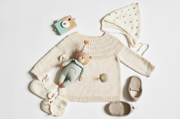 Foto kinderstrick pullover mütze schühchen socken holzbeißring nippel baby shower party geburtsvorbereitung flach liegend