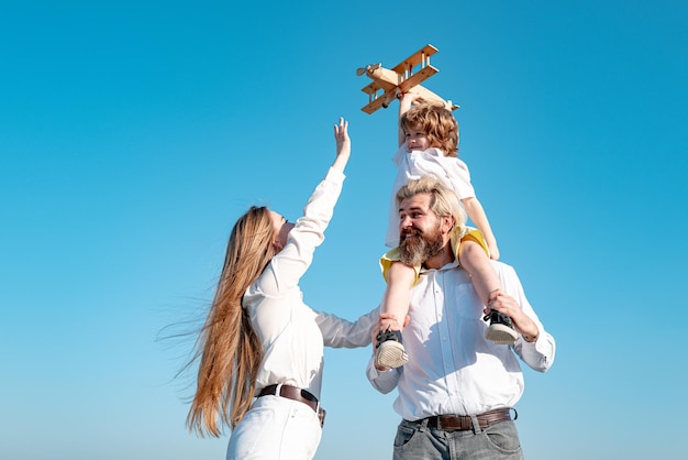 Kindertag glückliche Familie Mutter Vater und Kind mit Spielzeugflugzeug Kind träumt Zukunftsträume und tr