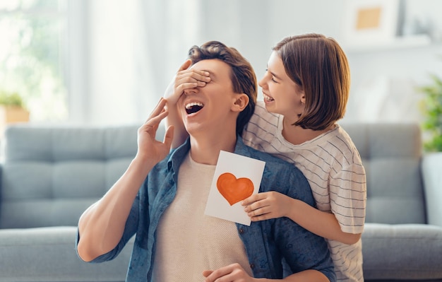 Kindertochter gratuliert ihrem Vater und gibt ihm eine Postkarte