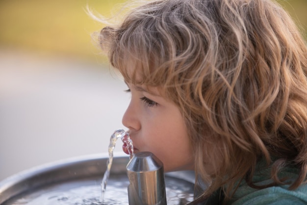 Kindertrinkwasser aus einem Wasserbrunnen im Park im Freien