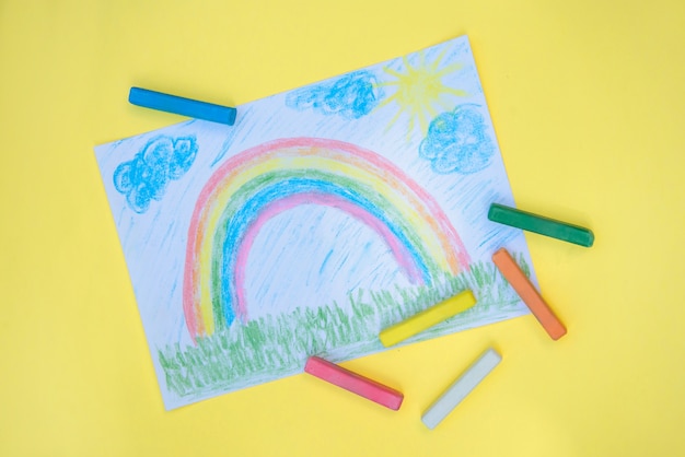 Kinderzeichnung mit buntem Regenbogen auf einem Stück Papier