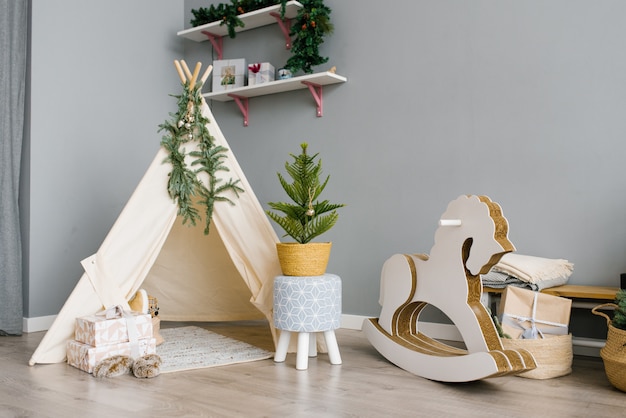 Foto kinderzimmer mit spielzeug, wigwam, pferd. weihnachtsdekor